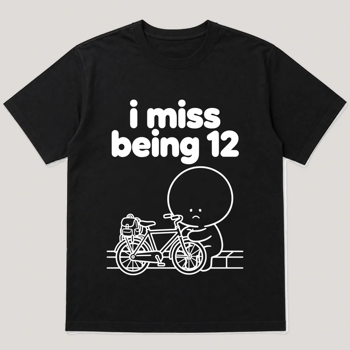 lonely boi tee: a small sad cartoon boy hugging a bike with a backpack by a curb, with the words i miss being 12 above him, Black front view