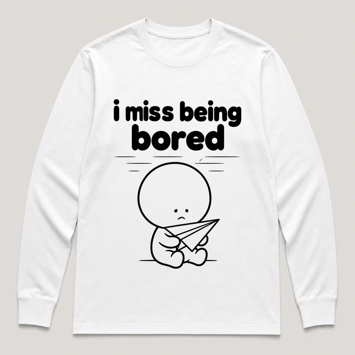 lonely boi tee: a small sad cartoon boy hugging a paper airplane drifting across a ceiling, with the words i miss being bored above him, White front view