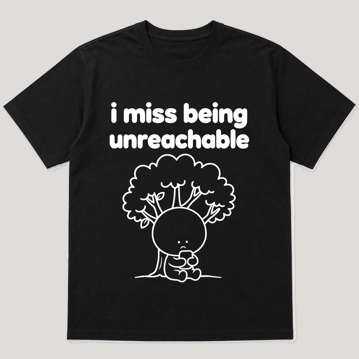 lonely boi tee: a small sad cartoon boy hugging a phone with no signal bars under a tree, with the words i miss being unreachable above him, Black front view