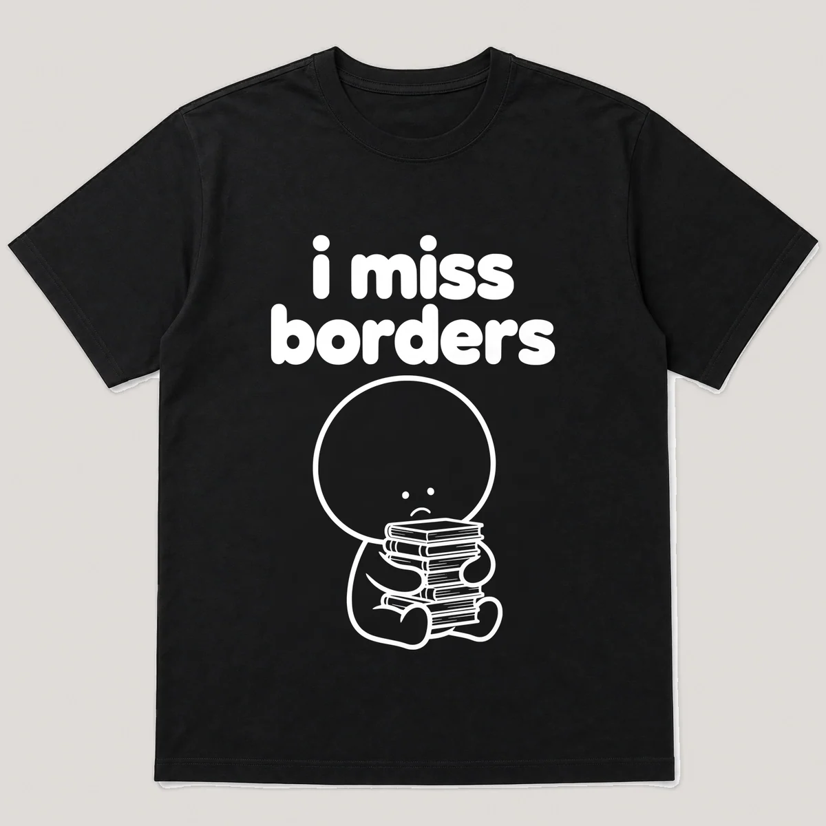 lonely boi tee: a small sad cartoon boy hugging a tall stack of paperback books, with the words i miss borders above him, Black front view