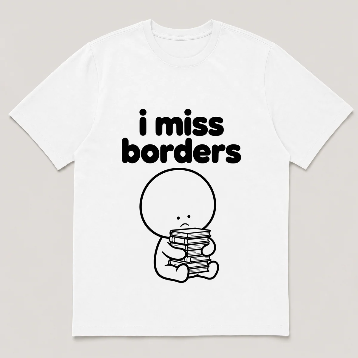 lonely boi tee: a small sad cartoon boy hugging a tall stack of paperback books, with the words i miss borders above him, White front view