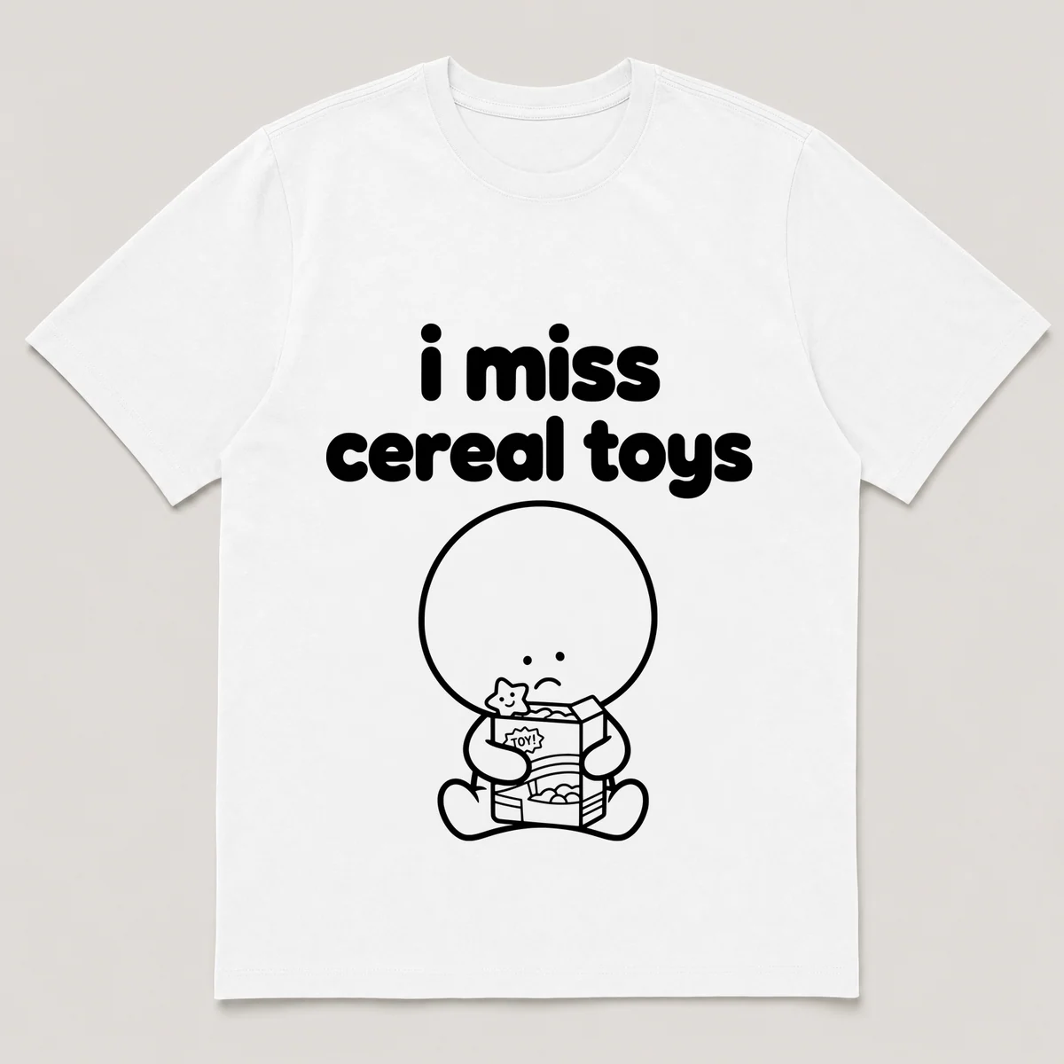 lonely boi tee: a small sad cartoon boy hugging a cereal box with a toy surprise, with the words i miss cereal toys above him, White front view