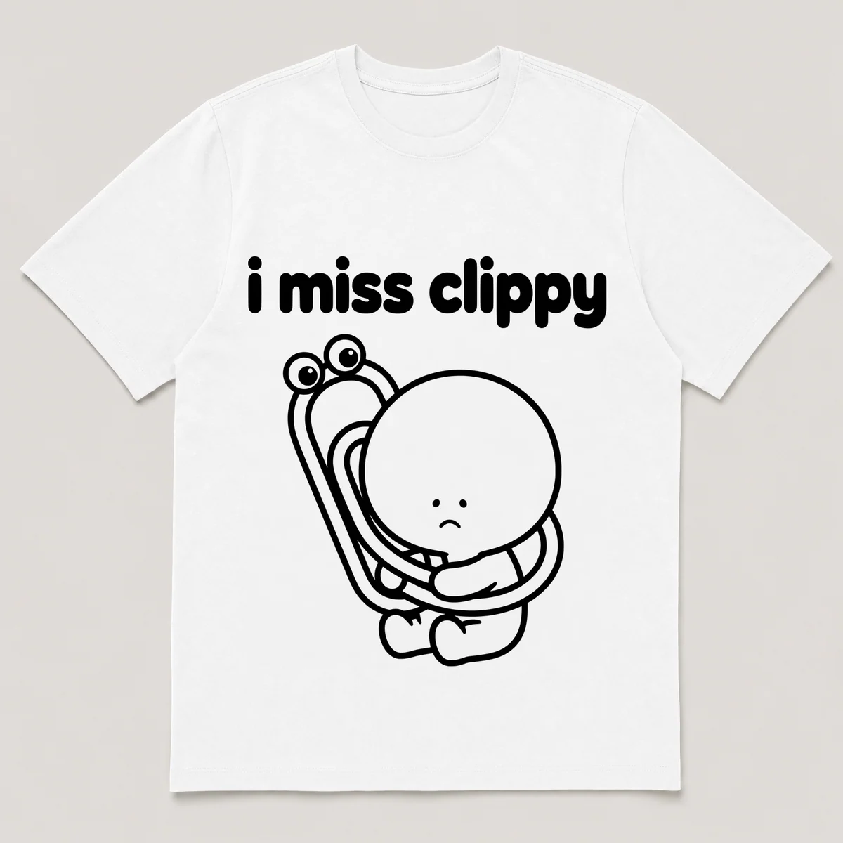 lonely boi tee: a small sad cartoon boy hugging a bendy paperclip with googly eyes, with the words i miss clippy above him, White front view