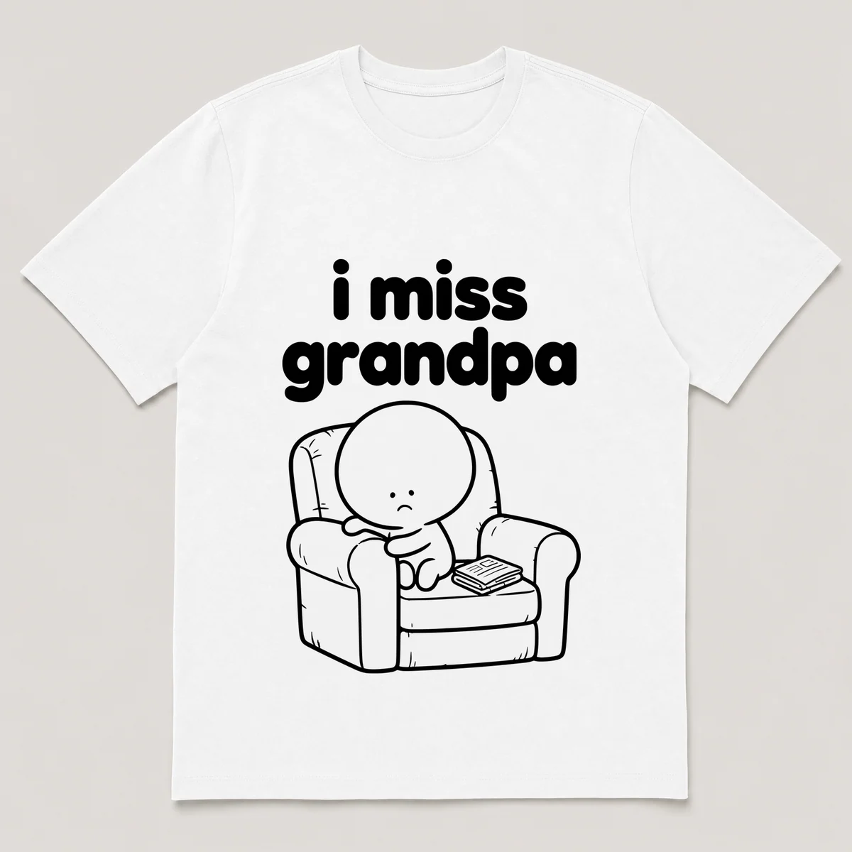 lonely boi tee: a small sad cartoon boy hugging a worn armchair with a folded newspaper, with the words i miss grandpa above him, White front view