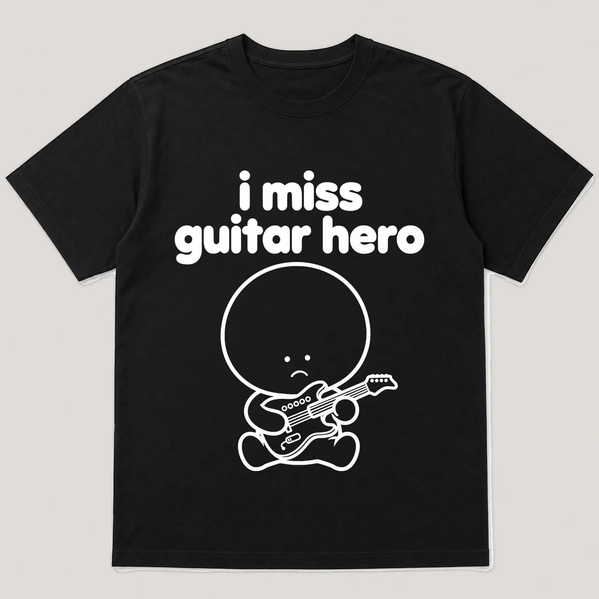 lonely boi tee: a small sad cartoon boy hugging a small plastic guitar controller, with the words i miss guitar hero above him, Black front view