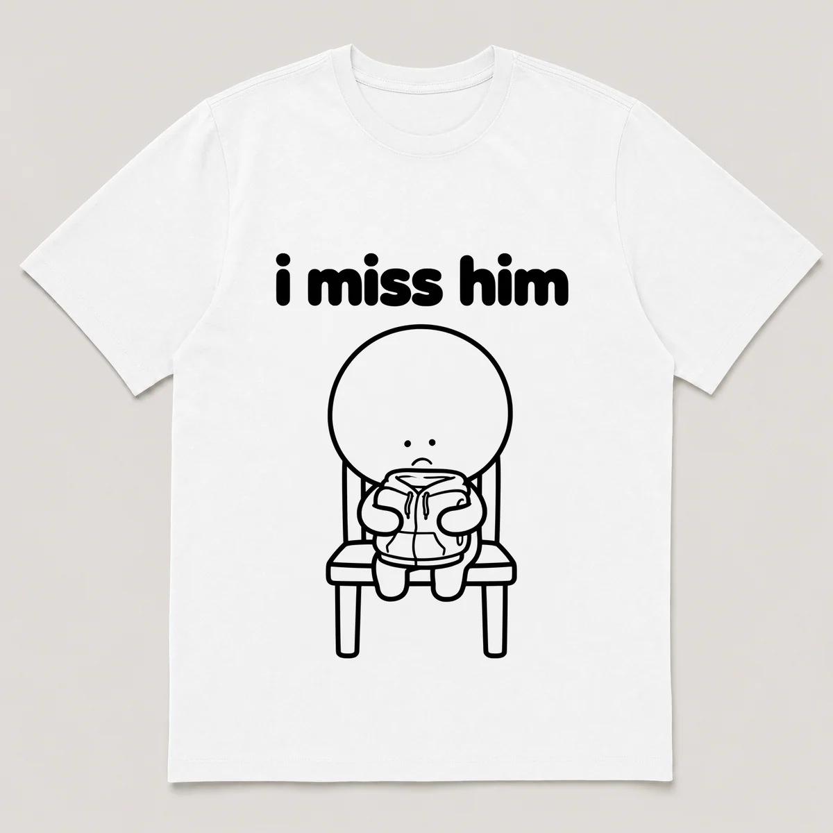lonely boi tee: a small sad cartoon boy hugging a folded hoodie left on a chair, with the words i miss him above him, White front view