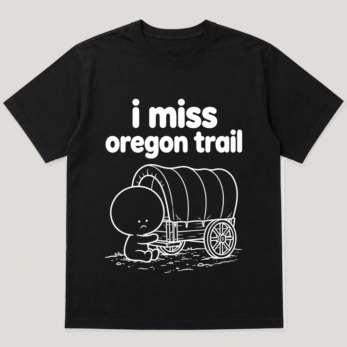 lonely boi tee: a small sad cartoon boy hugging a covered wagon on a dusty trail, with the words i miss oregon trail above him, Black front view