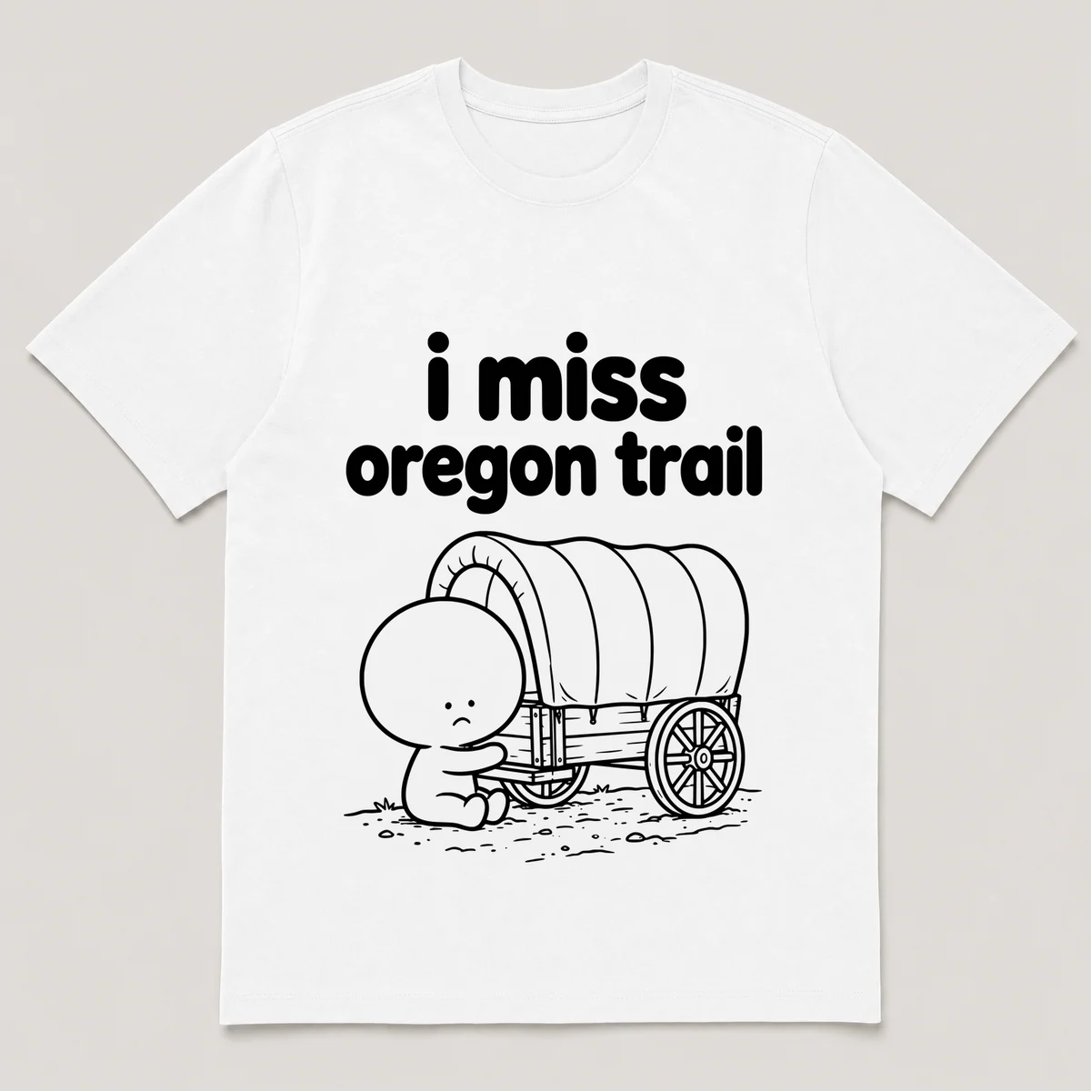 lonely boi tee: a small sad cartoon boy hugging a covered wagon on a dusty trail, with the words i miss oregon trail above him, White front view