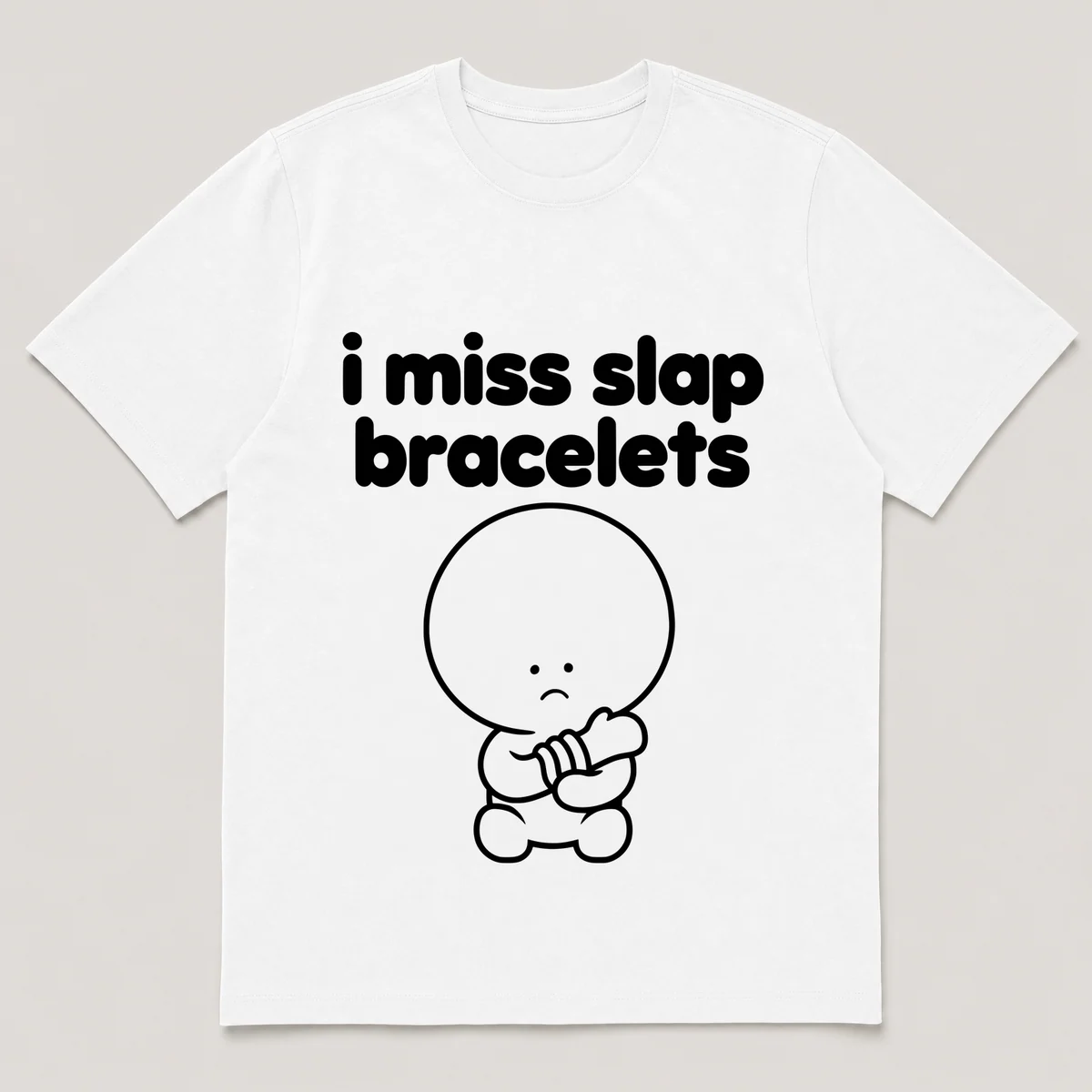 lonely boi tee: a small sad cartoon boy hugging a curled slap bracelet around a wrist, with the words i miss slap bracelets above him, White front view