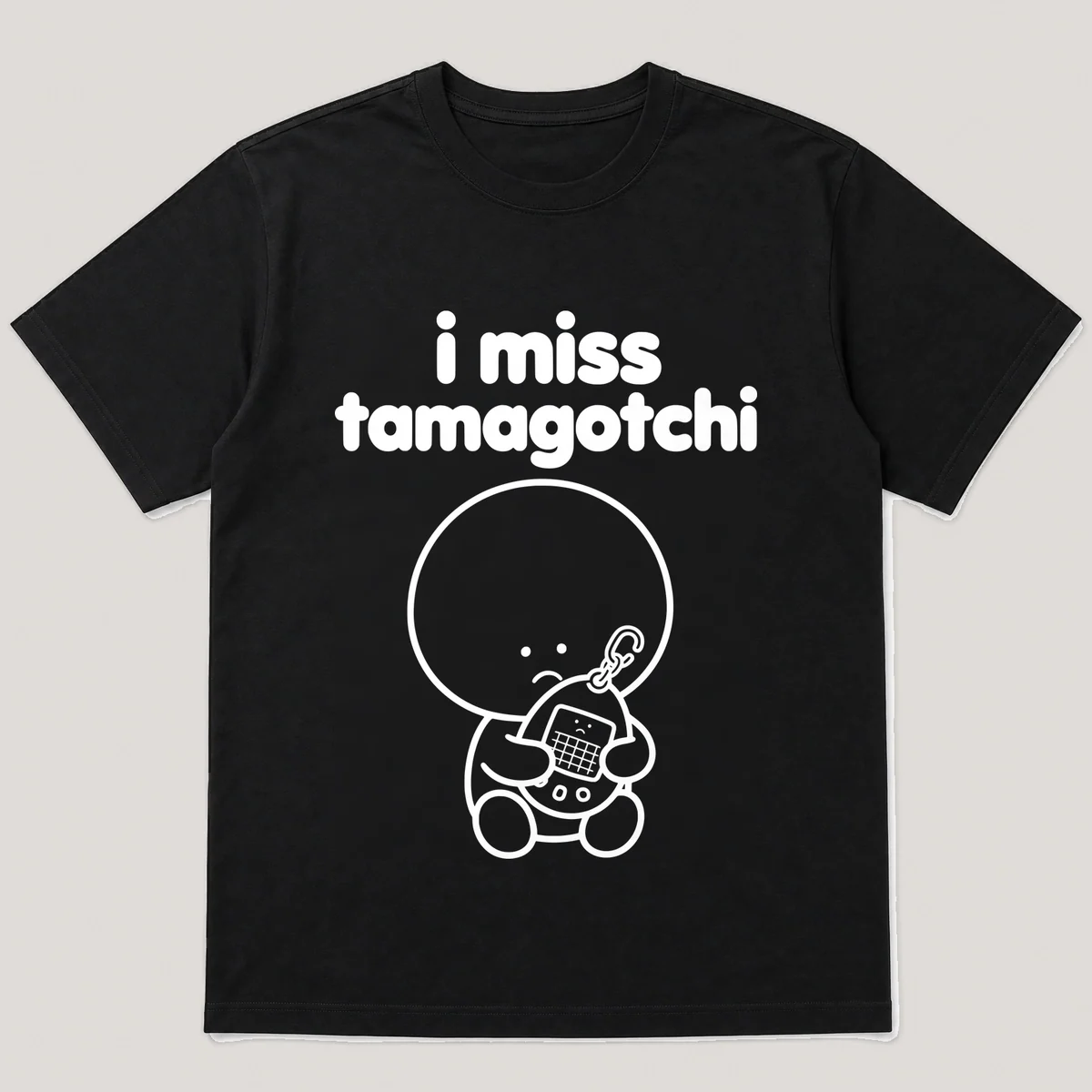 lonely boi tee: a small sad cartoon boy hugging an egg-shaped virtual pet keychain, with the words i miss tamagotchi above him, Black front view