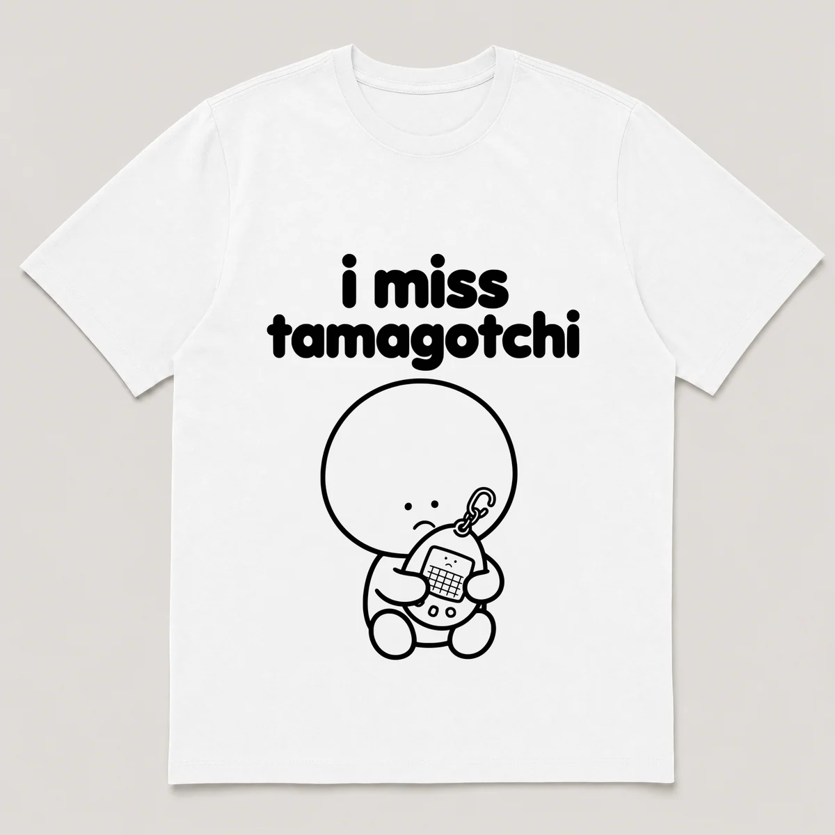 lonely boi tee: a small sad cartoon boy hugging an egg-shaped virtual pet keychain, with the words i miss tamagotchi above him, White front view